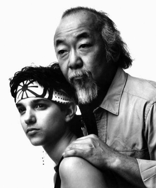 the karate kid movie characters mr miyagi on the back shoulder of young daniel-san in greenest dallas