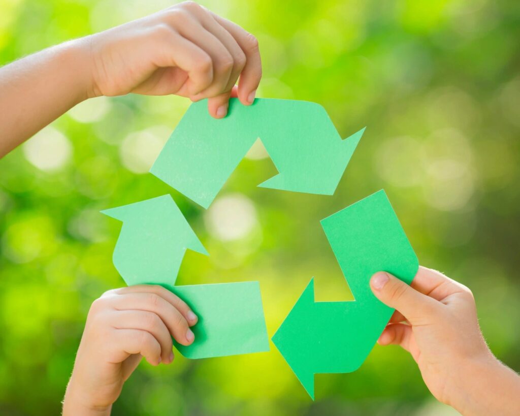 sustainable green miyagi kids hands holding a recycle symbol